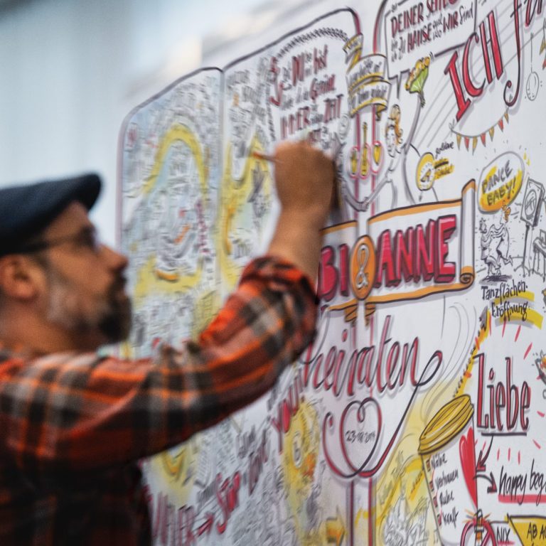 Foto, Illustrator Tobias Wieland beim Zeichnen eines Graphic Recording